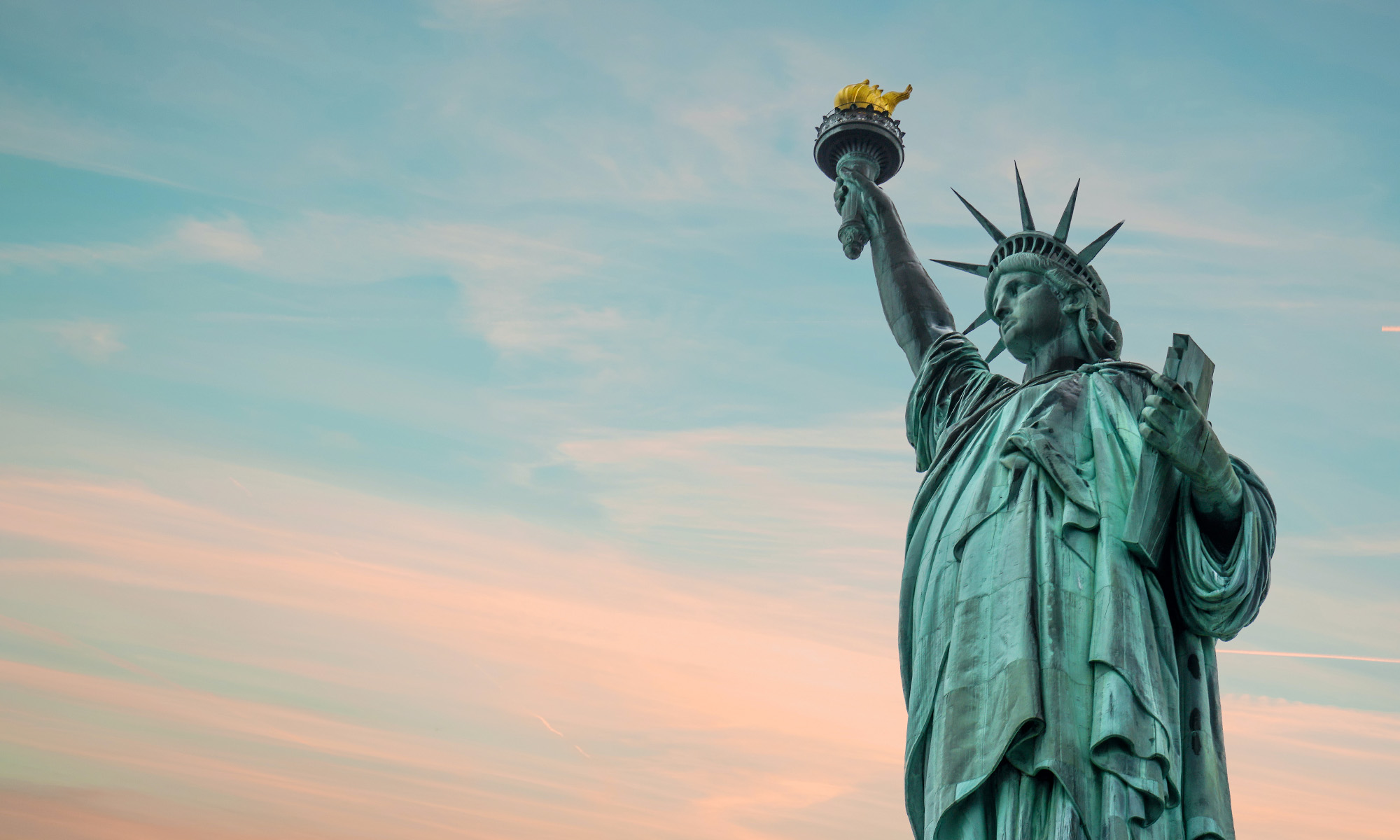 statue of libery against blue orange sky