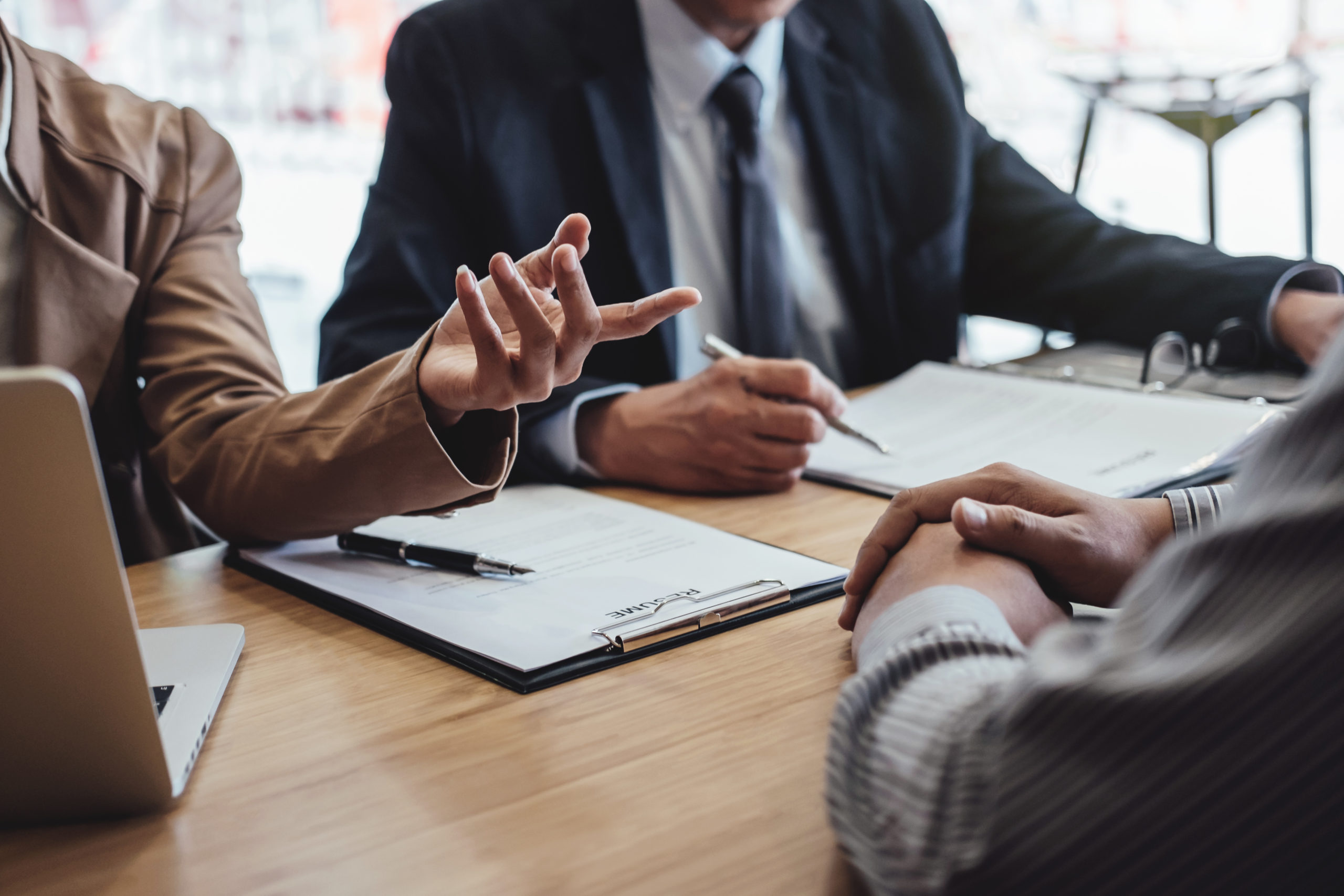 Two senior managers interview a young male interviewee